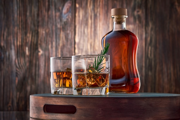 Gläser Whisky und eine Flasche auf dem Holztisch
