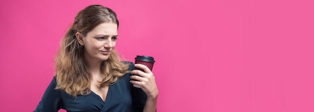 Glamour-Frau mit einem Drink Kaffee auf rosa Hintergrund