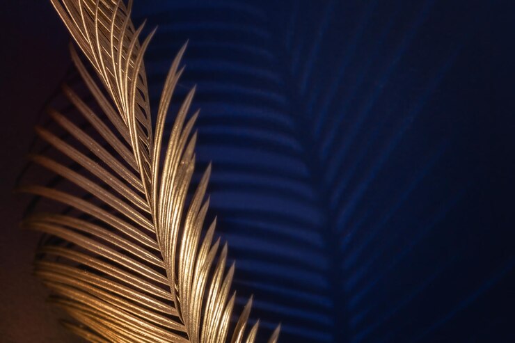 Foto glamour goldene tropische blätter und schatten auf dunkelblauem hintergrund art-deco-stil selektiver fokus