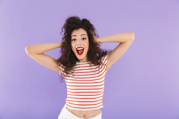 Glamour mujer morena con el pelo rizado en ropa de verano riéndose y mirándote