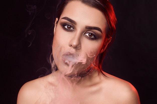 Glamour seductora hermosa mujer morena fumando cigarrillo electrónico