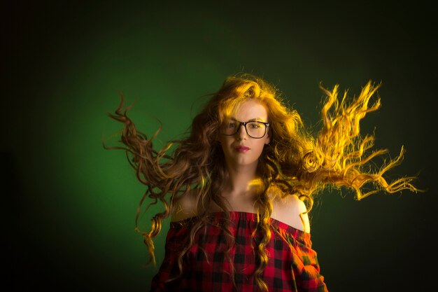 Glamouröse junge Frau mit Brille mit Haaren in Bewegung