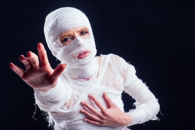 Glamouröse Mumienfrau in Verbänden auf ihrem schwarzen Studiohintergrund