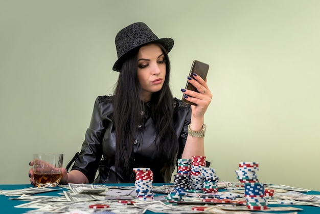 Glamouröses Mädchen im Casino mit Handy