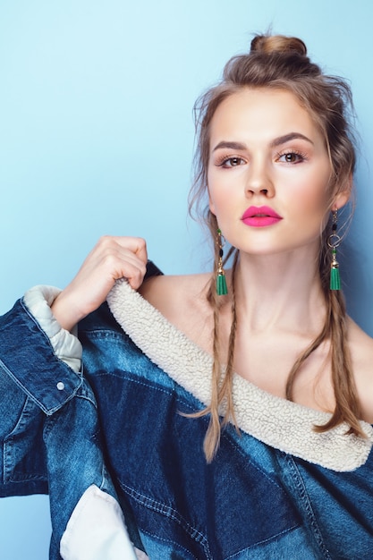 Glamouröses Mädchen mit leuchtend rosa Lippen, die Jeansjacke tragen