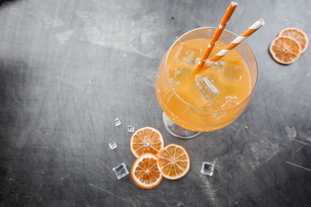 Glas Aperolsoda-Cocktail mit Eiswürfeln über Dunkelheit