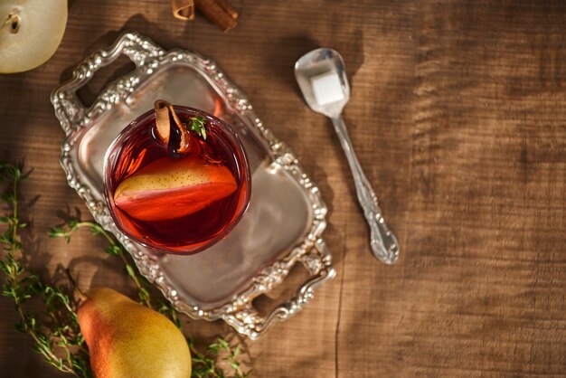 Glas Apfelweinbirnencocktail oder Limonade, Zimtstangen, Anissterne auf Holzoberfläche.