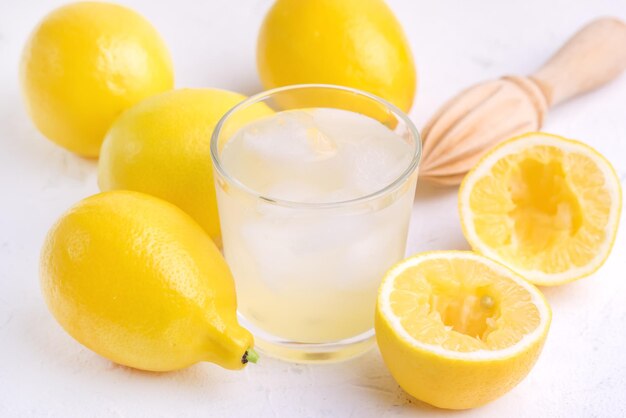 Glas ar mit kalter leckerer frischer Limonade mit reifen Zitronen Holzpresse Nahaufnahme