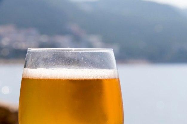 Glas Bier am frühen Morgen am Strand