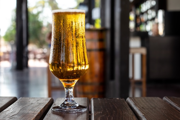 Glas Bier auf einem Holztisch in einer Kneipe, Bar. Alkoholisches Getränk. Party, Freizeitkonzept.