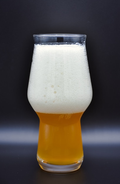 Glas Bier mit Schaum isoliert auf schwarz