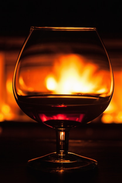 Glas Cognac vor dem Kamin