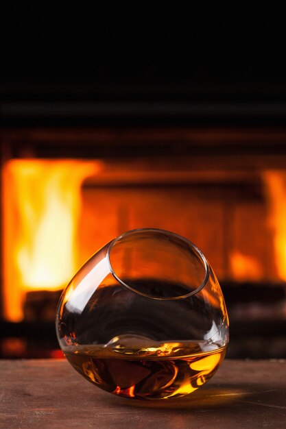 Glas Cognac vor dem Kamin