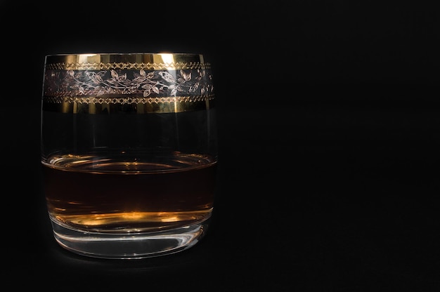 Glas dunkelroter Whisky-Brandy oder xAbourbon isoliert auf schwarzem Hintergrund Nahaufnahmefoto von Alkohol