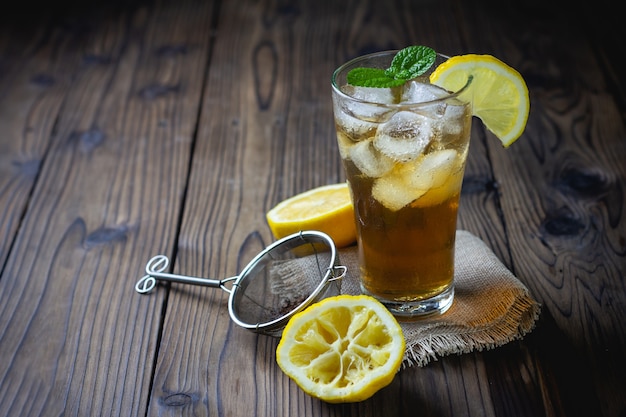 Foto glas eistee mit zitrone auf holztisch