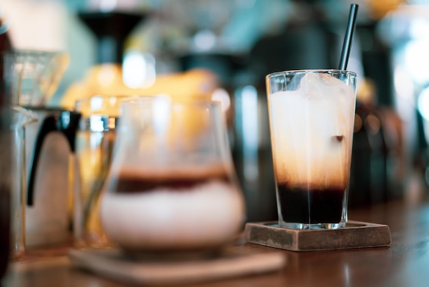Glas Espresso mit Milch auf der Bar im Café, schönes helles Bokeh als Hintergrund