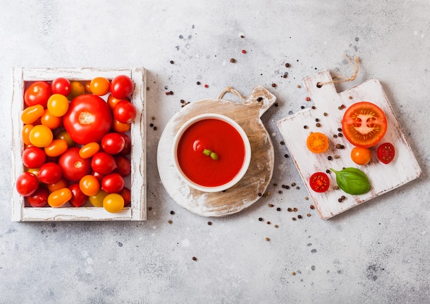 Glas frische Bio-Tomatenmark mit frischem rohem Tomatenbasilikum und Pfeffer in der Schachtel