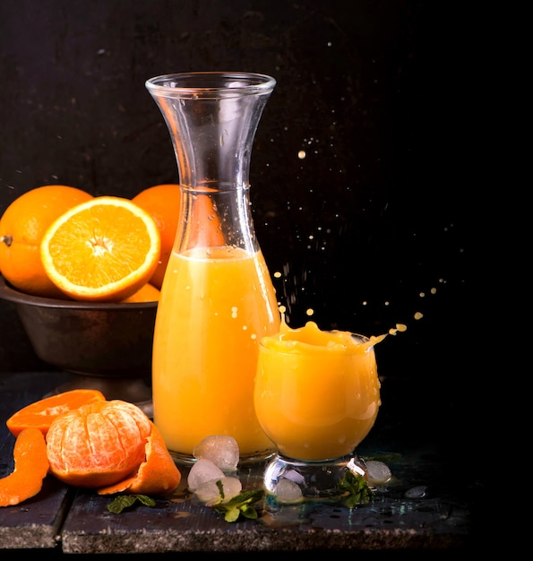 Glas frischen Orangensaft mit frischen Früchten auf Holztisch