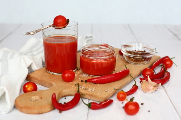Glas frischer Bio-Tomatensaft mit frischen rohen Tomaten und Pfeffer