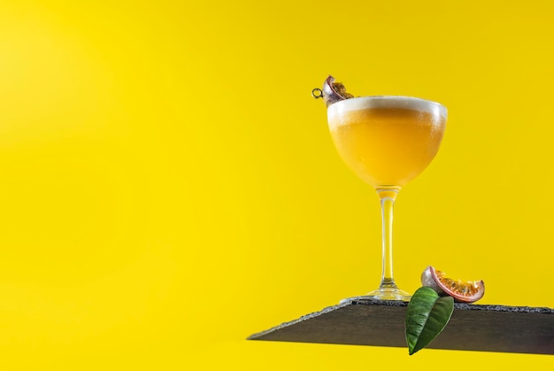 Glas frischer Passionsfrucht-Martini-Cocktail auf leuchtend gelbem Hintergrund Frühlings-Sommer-Kunstgetränk-Food-Konzept