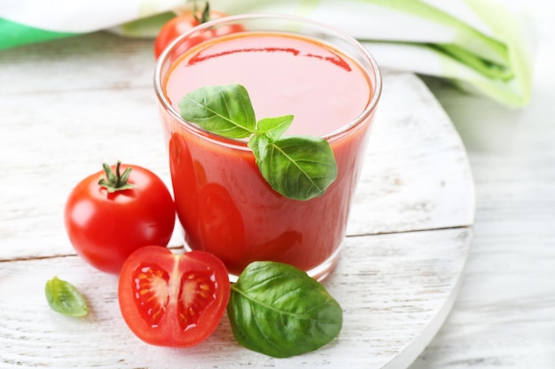 Glas frischer Tomatensaft auf Holztisch Nahaufnahme