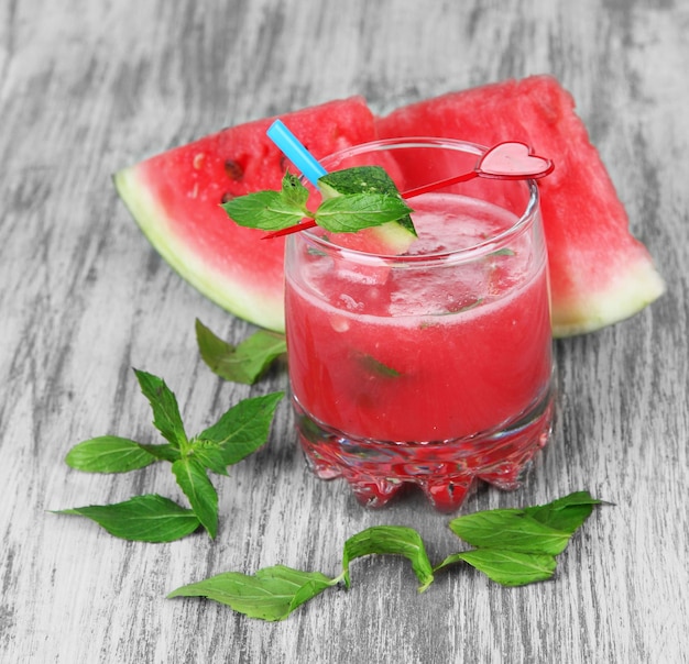 Glas frischer Wassermelonensaft auf Holztisch auf Holzhintergrund