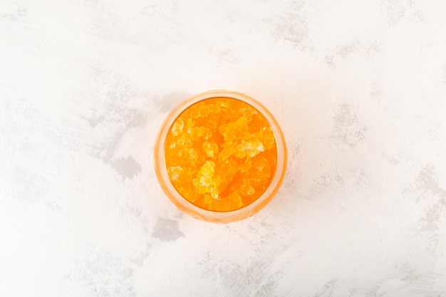 Glas gefrorener Orangensaft, Ansicht von oben. Granizado-Orange. Slushie-Getränk. Eisgekühltes Fruchtgetränk. Geraspeltes Eis.