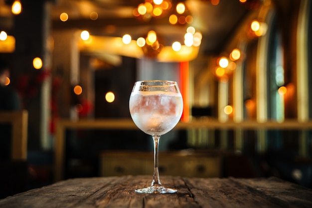 Glas Gin Tonic Cocktail auf dem Holzschreibtisch