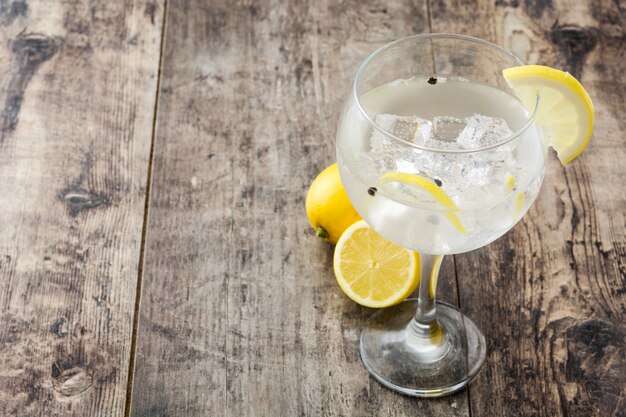 Glas Gin Tonic mit Zitrone auf Holztisch