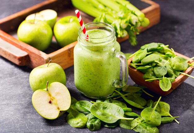 Glas Glas grünen Saft Smoothie mit Spinat, Apfel und Sellerie auf dunkel