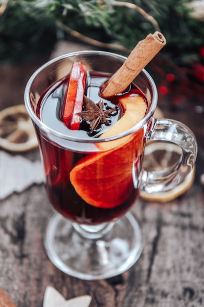 Glas Glühwein mit Orange, Apfel und Gewürzen. Erwärmendes Neujahrsgetränk.