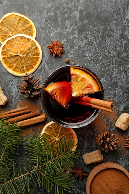 Glas Glühwein und Zutaten auf schwarzem Smokey