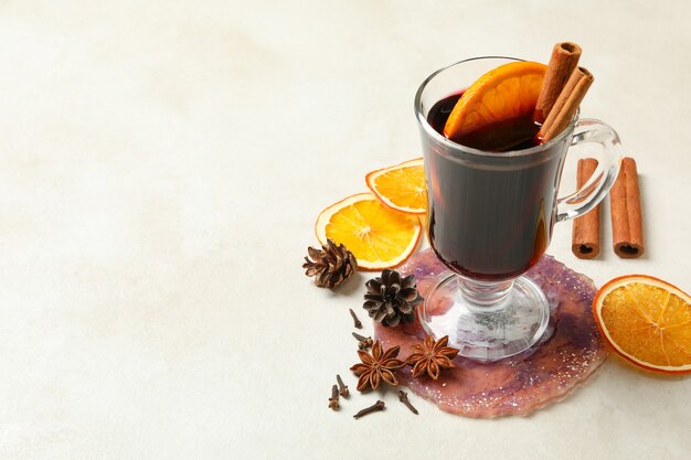 Glas Glühwein und Zutaten auf weißem Hintergrund