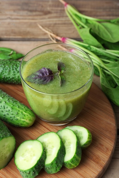 Glas grüner, gesunder Saft mit Spinat und Gurken auf dem Tisch aus nächster Nähe