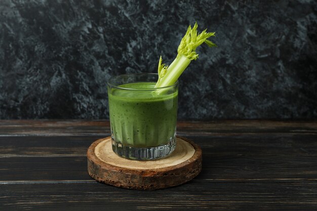 Glas grüner Smoothie mit ery elery an Bord auf Holztisch