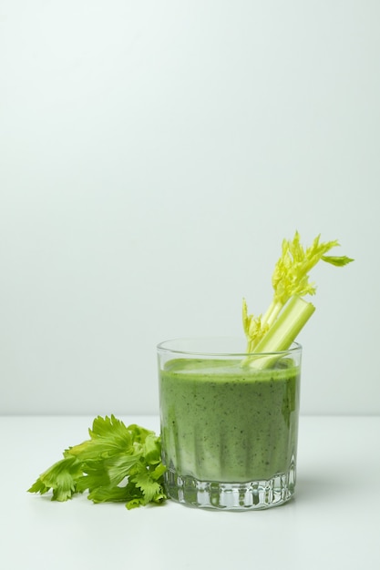 Glas grüner Smoothie mit ery elery auf weißem Tisch