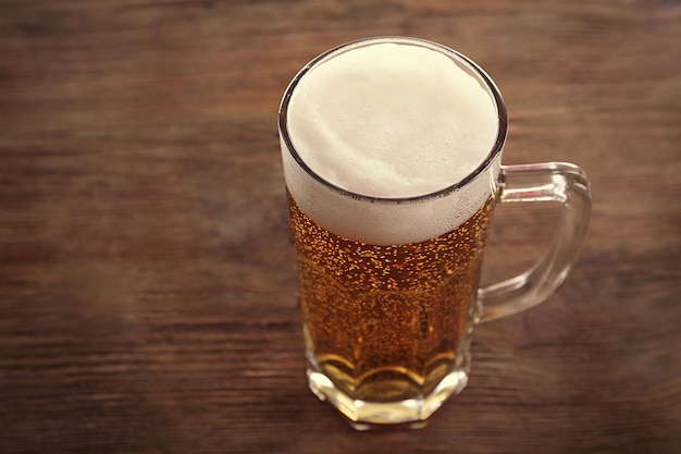 Foto glas helles bier auf hölzernem hintergrund