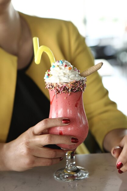 Glas Himbeermilchshake mit Schlagsahne und frischen Himbeeren