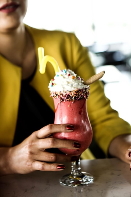 Glas Himbeermilchshake mit Schlagsahne und frischen Himbeeren