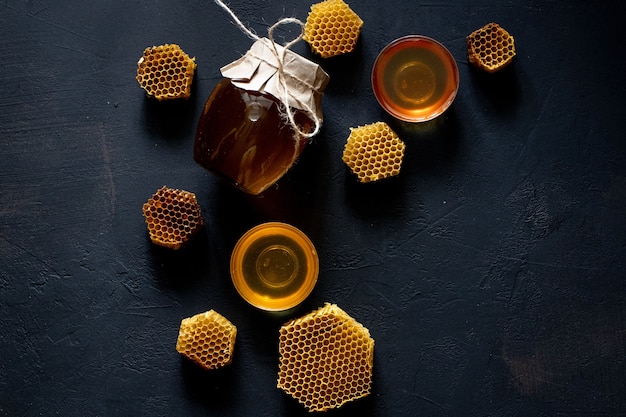 Glas Honig mit Wabe auf schwarzem Tisch