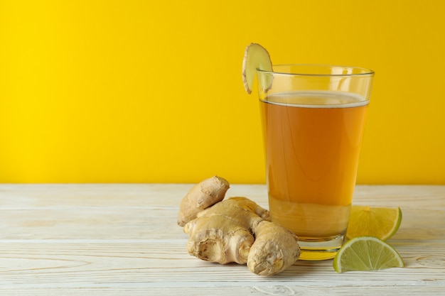 Glas Ingwerbier und Zutaten auf weißem Holztisch