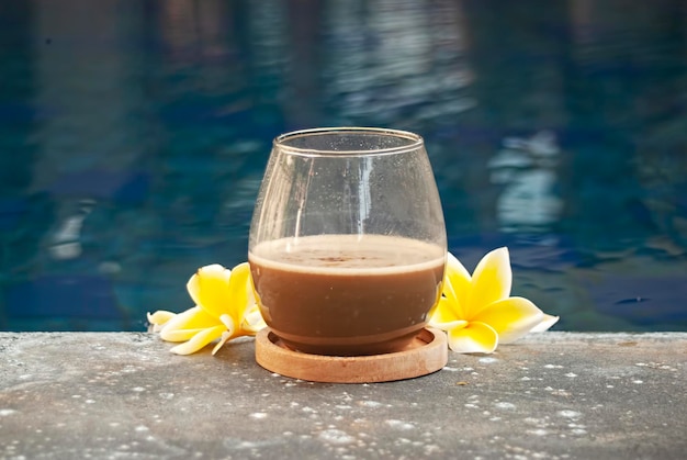 Glas Kaffee Latte auf schönem Swimmingpool