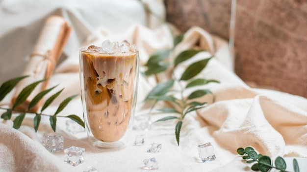 Glas Kaffee mit Milch auf einer weißen Leinwand