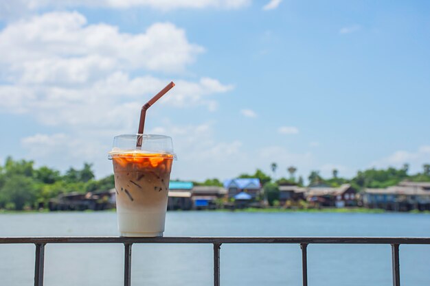 Glas kalter Espressokaffee auf dem eisernen Balkon mit Blick auf den Fluss und das Haus.