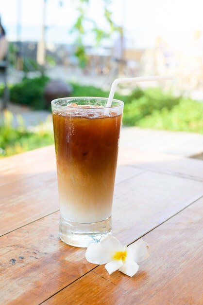 Glas kalter Kaffee auf Holztisch