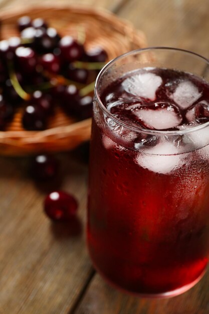 Glas Kirschsaft auf Holztisch Nahaufnahme