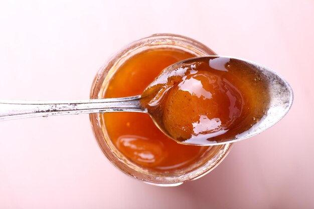 Glas leckere Marmelade auf Holzhintergrund