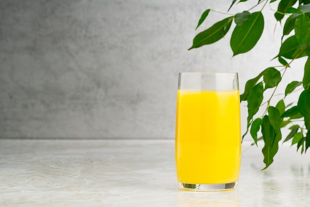 Glas leckeren Orangensaft auf dem Tisch Glas Orangensaft mit Kopierraum auf grauem Hintergrund