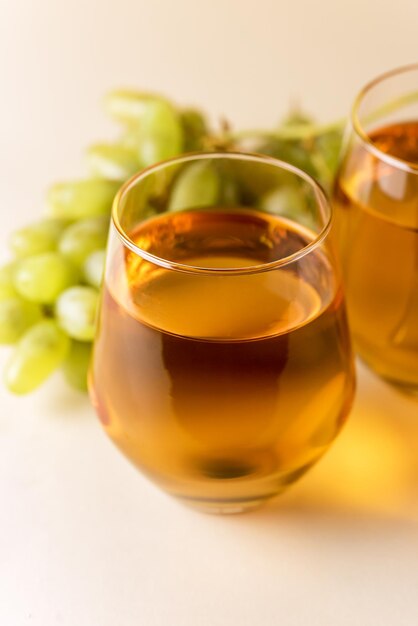 Glas leckeren Traubensaft auf gelbem Hintergrund Gesundes Getränk Raw Green Grape Vertikal