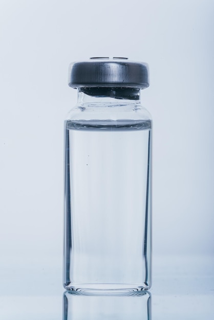 Glas medizinische Ampullenfläschchen zur Injektion Medizin ist trockenes weißes Medikament Penicillinpulver oder Flüssigkeit mit wässriger Lösung in Ampulle Nahaufnahme Flaschenampulle mit Aluminiumkappe auf grauem Hintergrund